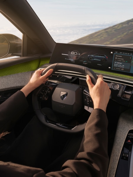 Man achter het stuur van een Peugeot E-5008, detail van de i-cockpit