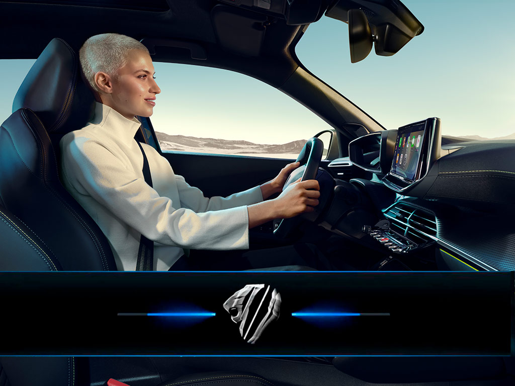 Een vrouw rijdt in de PEUGEOT E-2008