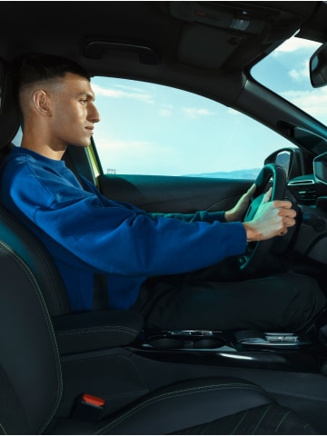 Een man bestuurt de PEUGEOT E-208